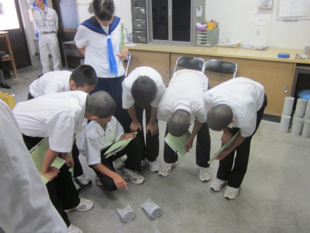 コンクリートを実際に圧縮試験した後、生徒たちが断面や状態を確認させてもらっている様子