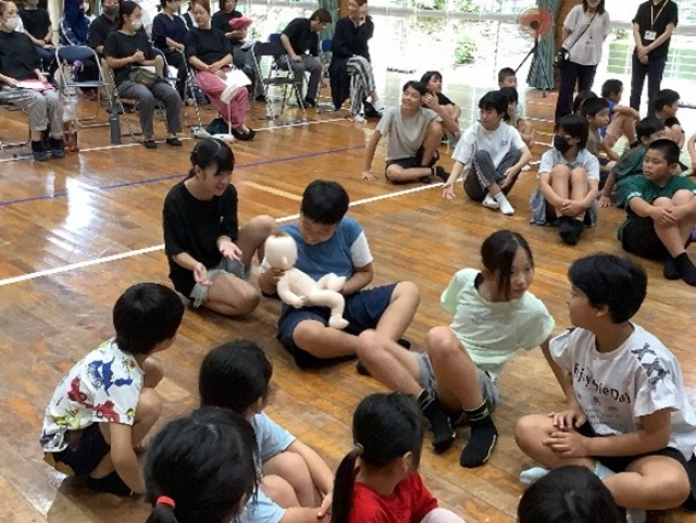 胎児人形を抱っこする子ども達